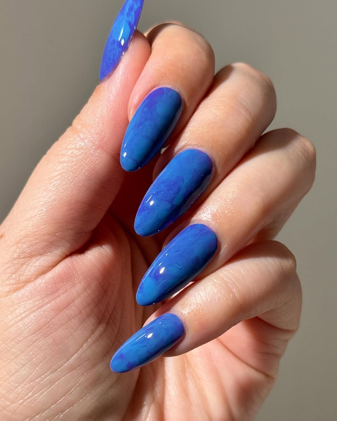 Glossy Blue Water Marble Almond Nails
