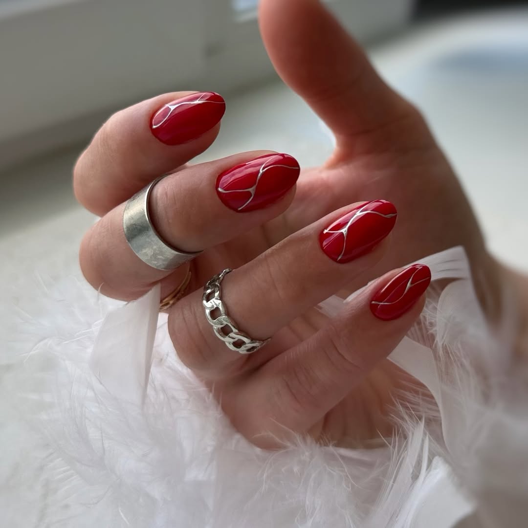 Glossy Red Almond Nails With Silver Abstract Swirls