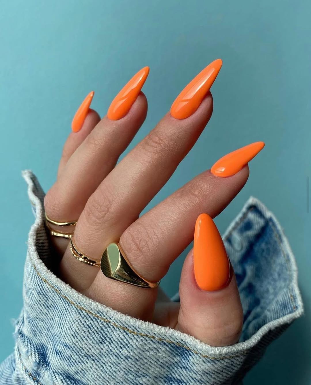 Vibrant Glossy Orange Stiletto Nails with Blue Jean Cuff