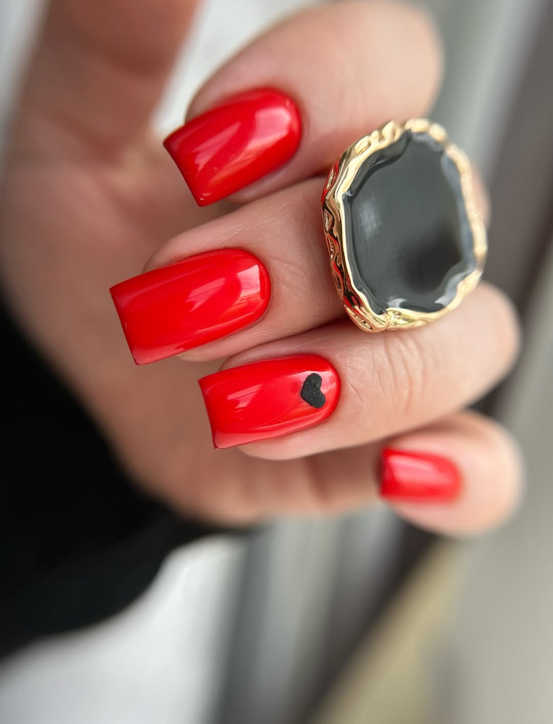 Vibrant Red Glossy Square Nails with Black Heart Accent
