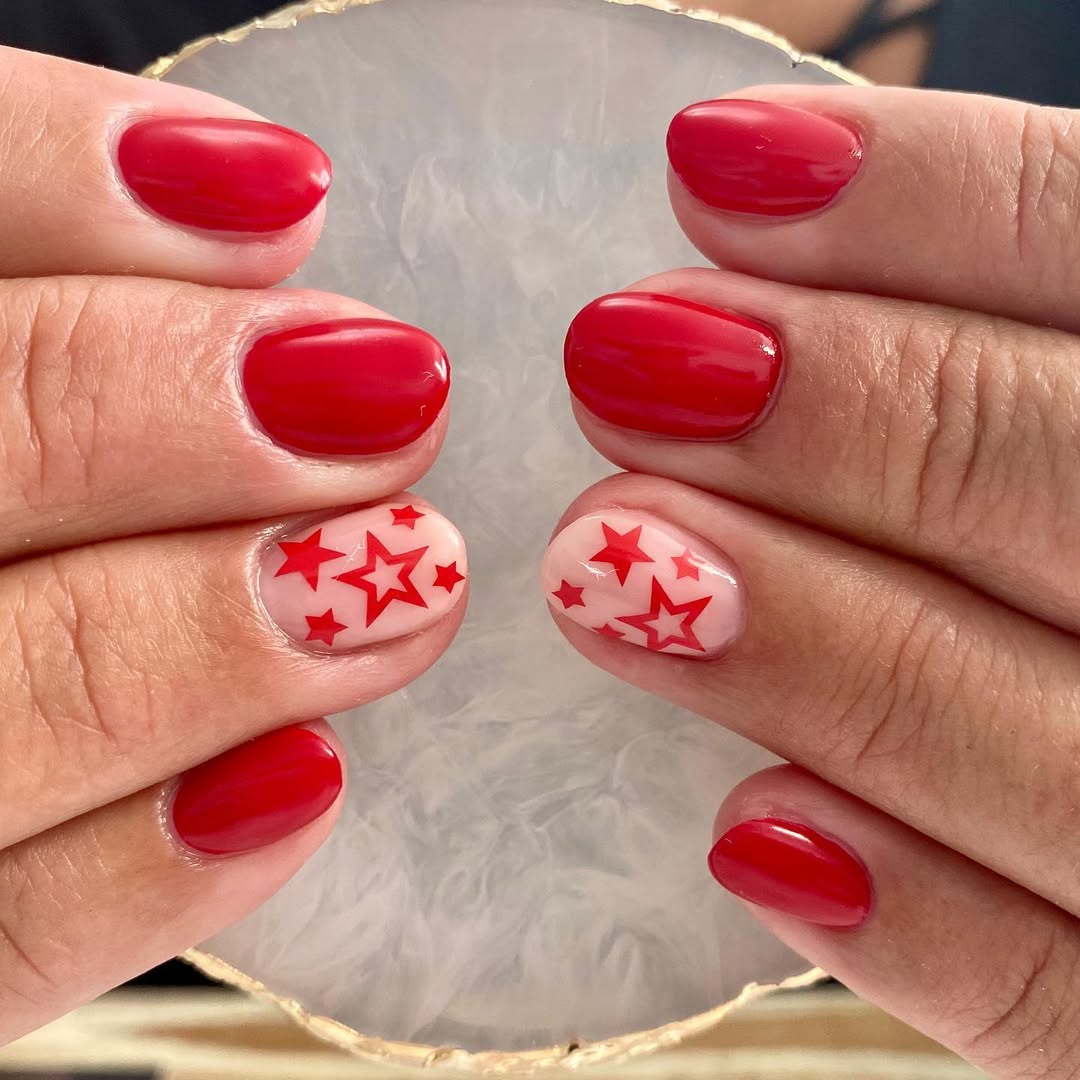 Vibrant Red Nails With Star Accent Short Oval