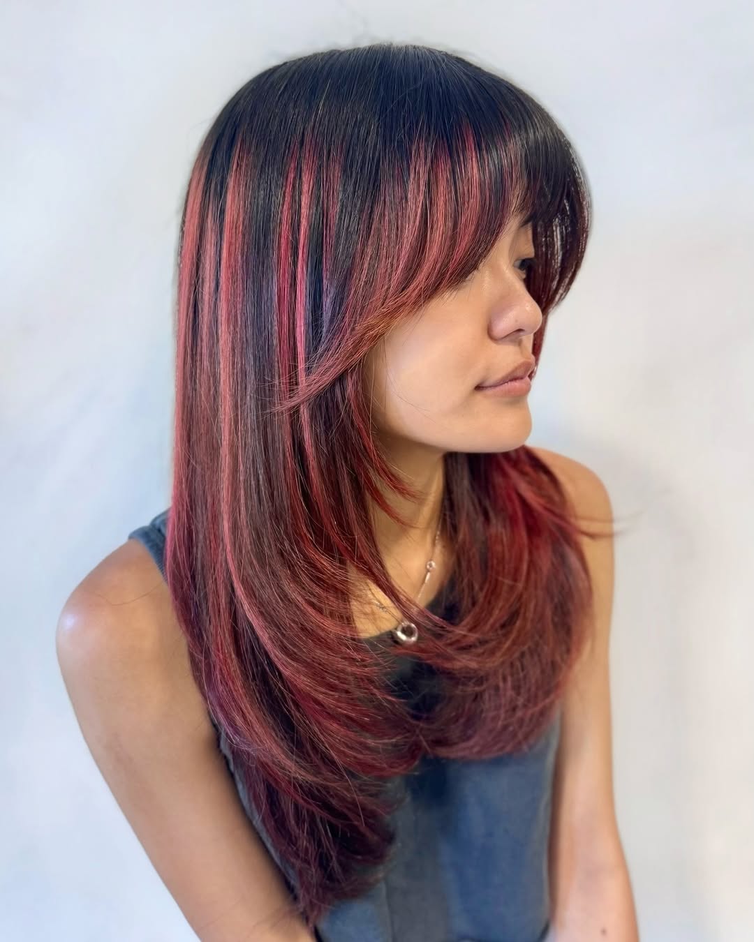 Crimson Highlights On Medium Layered Cut With Bangs