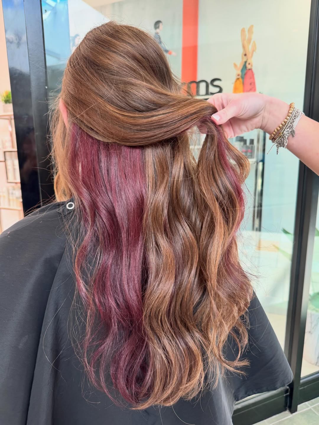 Deep Plum Peekaboo On Wavy Brunette Hair