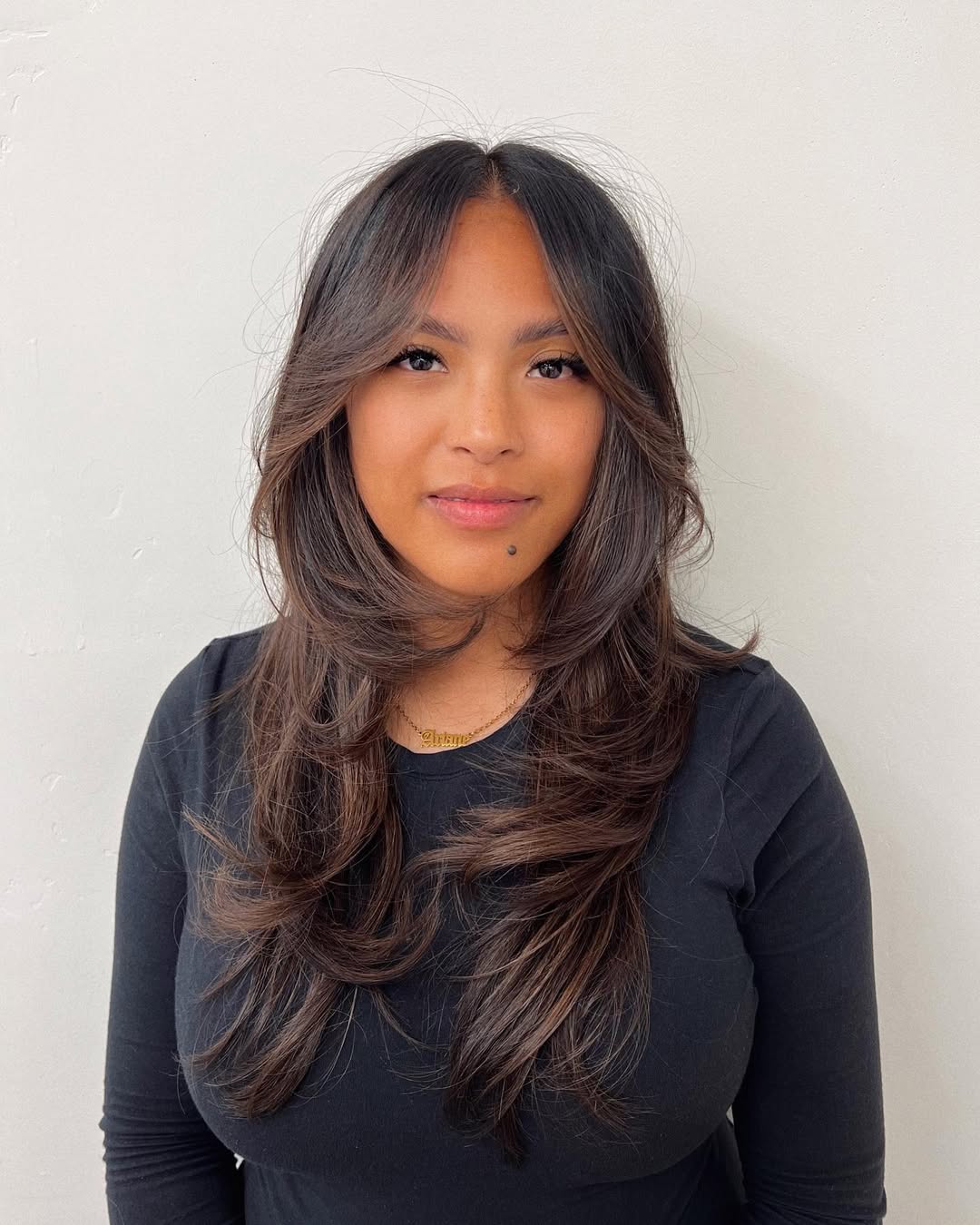 Fluffy Layers And Face-Framing Bangs On Dark Brown Hair
