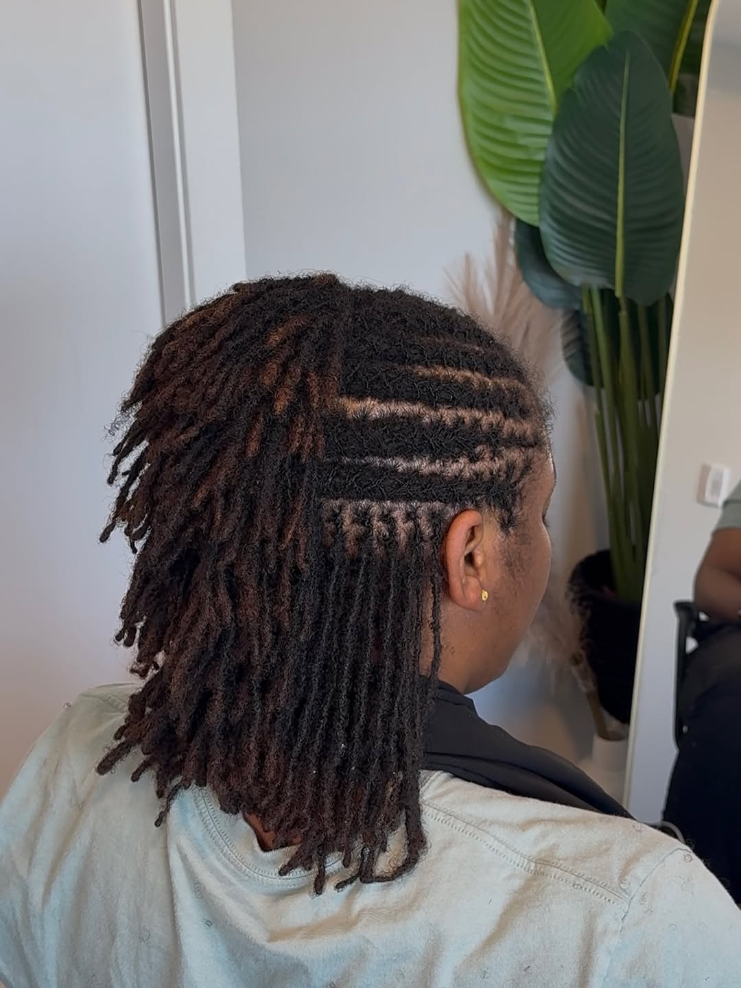 Styled Locs With Undercut Design And Dark Roots