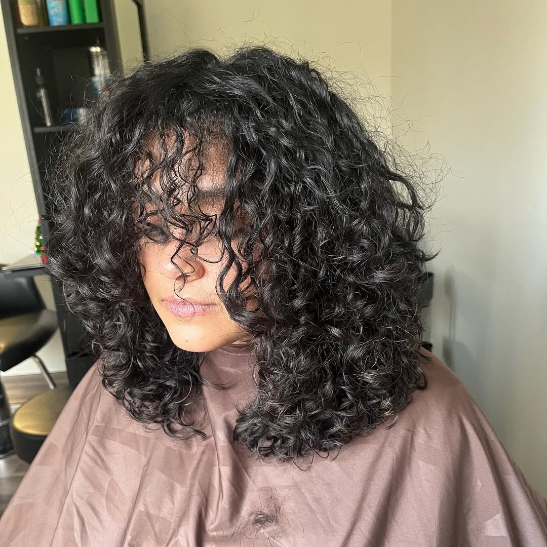 Voluminous Dark Curly Shag with Wispy Bangs
