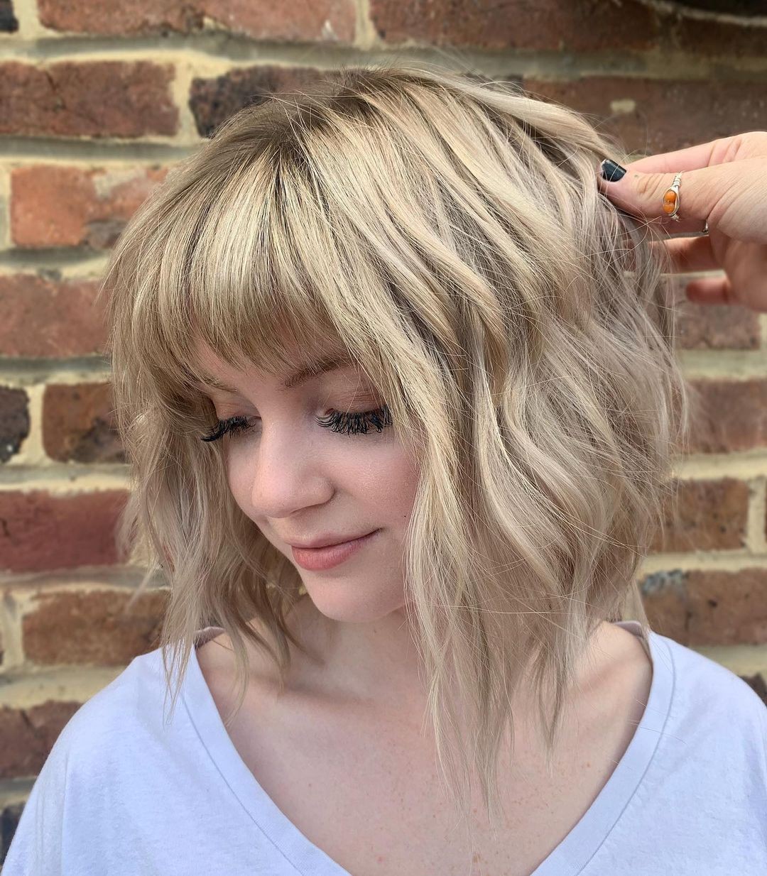 Wavy Platinum Blonde Lob With Full Choppy Bangs