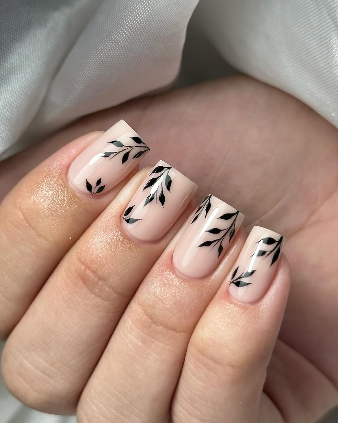Elegant Nude Nails with Black Leaf Accents